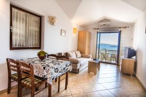 uma sala de estar com uma mesa e um sofá em Apartments Adria em Biograd na Moru