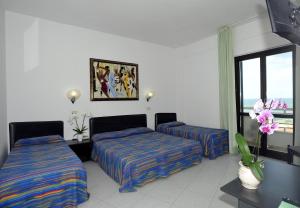 una camera d'albergo con due letti e una finestra di Hotel Borgo Marina a Rodi Garganico