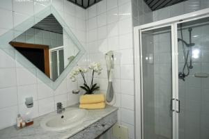 a bathroom with a sink and a shower and a mirror at Hotel Borgo Marina in Rodi Garganico