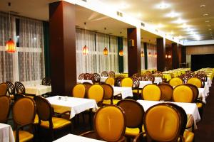 restauracja z białymi stołami i żółtymi krzesłami w obiekcie Hotel Medlov Depandance w mieście Fryšava
