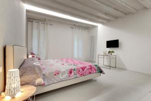 una camera bianca con letto e TV di Bacchus Venice Residence a Venezia
