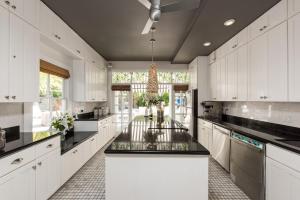 a large kitchen with white cabinets and black counter tops at Alexander's Gay Lesbian Guesthouse (Adult Only 21+) in Key West