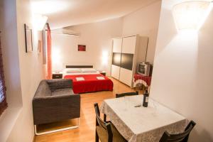 a small room with a bed and a table and chairs at Apartments Adria in Biograd na Moru