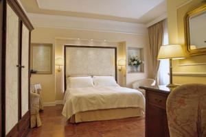 een slaapkamer met een bed en een tafel en stoelen bij Parco del Lago Resort & SPA in Villagrande