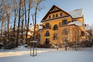 a house in the snow with a basketball hoop in front of it at Apartamenty-Plaza Zakopane in Zakopane
