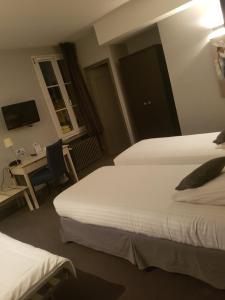 a hotel room with two beds and a desk at Logis - Hôtel du Nord et Restaurant La Table d'Elisa in Compiègne
