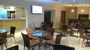 a restaurant with tables and chairs and a bar at Casa de Oliveira Hostel in Torres +3 photos