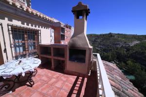 a outdoor patio with a fireplace and a table at Casa rural Vistas al Rio in Jorquera