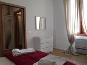 una camera da letto bianca con un letto e asciugamani di VIAXX 51 ad Alghero