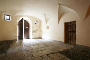 een lege kamer met twee deuren en een stenen vloer bij Casa Melide 3 in Bormio