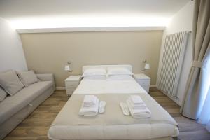 um quarto com uma cama grande e um sofá em Domus Dams B&B em Montescaglioso