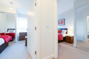 1 Schlafzimmer mit 2 Betten und einem Spiegel in der Unterkunft PSF Panorama Apartments in Ashford