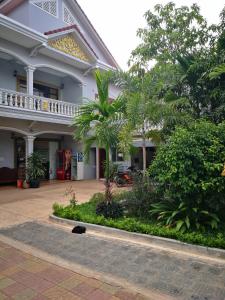 ein großes weißes Gebäude mit Bäumen und einem Innenhof in der Unterkunft Home Sweet Home in Siem Reap