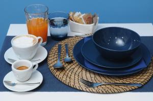 ナポリにあるLa Casa di Giorgio B&Bの青い皿とコーヒーカップが付いたテーブル