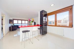 a kitchen with a red counter and stools at La Mata Beach Apartment in La Mata
