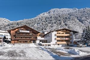 un grand bâtiment avec une montagne en arrière-plan dans l'établissement Hotel Alpenfeuer Montafon, à Sankt Gallenkirch