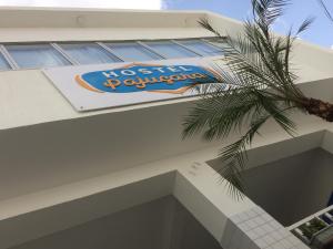 a sign on the side of a building with a palm tree at Hostel Pajuçara in Maceió