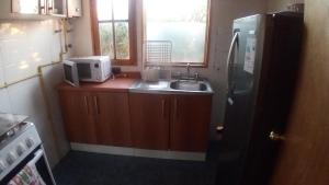 a small kitchen with a sink and a refrigerator at Rocas del Pirata in Quintero