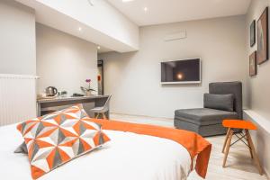 un dormitorio con una cama y una silla en Mandarina Hotel Luxembourg Strassen, en Luxemburgo