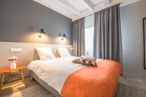 Un dormitorio con una cama grande y una ventana en Mandarina Hotel Luxembourg Strassen, en Luxemburgo