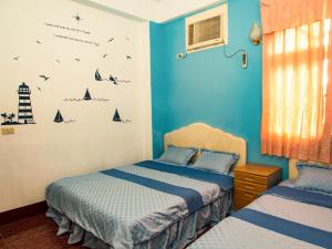 綠島鄉的住宿－綠島長泰民宿，蓝色墙壁客房的两张床