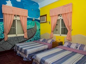 綠島鄉的住宿－綠島長泰民宿，墙上壁画的房间里设有两张床