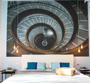 a spiral staircase mural in a bedroom with a bed at Milizie 76 Gallery in Rome