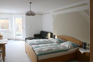 バート・エムスにあるPension Garni Haus Bismarckhöheのベッドルーム(ベッド1台、ソファ付)