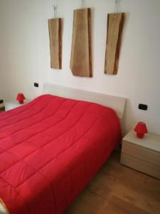 Cama roja en habitación blanca con manta roja en Domus Quietis en Venecia