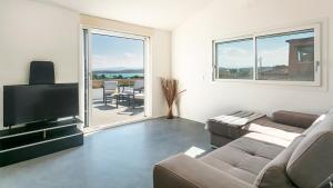 un soggiorno con divano e TV a schermo piatto di Sardegna é - Villa Charme&Design a Olbia