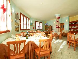 a restaurant with white tables and chairs and windows at Hotel Jasmine in Teulada