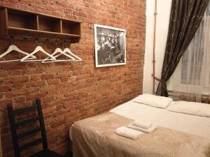 - une chambre avec un mur en briques et 2 lits dans l'établissement Antre Hotel, à Saint-Pétersbourg