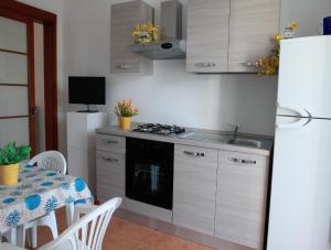 una cucina con tavolo, piano cottura e frigorifero di Villa Gio a Torre Suda