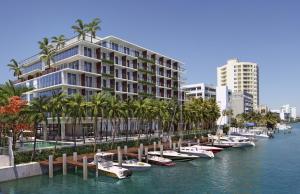 a row of boats in the water next to buildings at Grand Beach Hotel Bay Harbor in Miami Beach