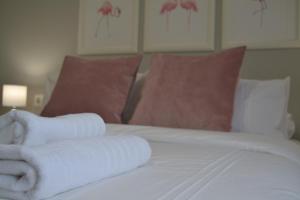 uma cama com duas toalhas enroladas em cima em Sherryflat Alcázar - Parking em Jerez de la Frontera
