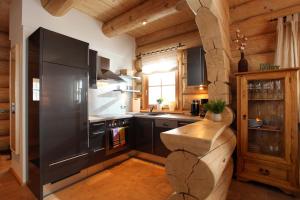 eine Küche mit schwarzen Geräten und einer Holzdecke in der Unterkunft Blockhaus Chalet Heim in Kirchberg in Tirol