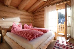 ein Schlafzimmer mit einem Bett in einer Blockhütte in der Unterkunft Blockhaus Chalet Heim in Kirchberg in Tirol