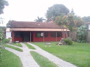 a red house with a pathway leading to it at Pousada Império estrada Real in Santa Cruz de Minas