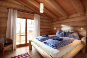 ein Schlafzimmer mit einem Bett in einer Blockhütte in der Unterkunft Blockhaus Chalet Heim in Kirchberg in Tirol