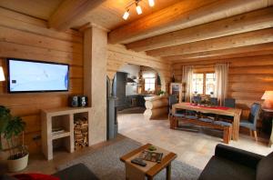 ein großes Wohnzimmer mit einem TV und einem Wohnzimmer in der Unterkunft Blockhaus Chalet Heim in Kirchberg in Tirol