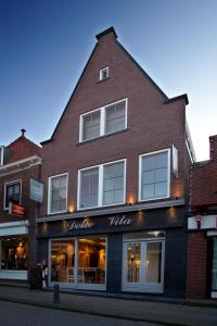 
a brick building with a sign on the side of it at DV Groep Bed & Breakfast in Volendam

