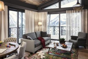 een woonkamer met een bank en een tafel bij Valsana Hotel Arosa - Small Luxury Hotel in Arosa
