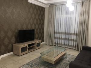 a living room with a flat screen tv on a stand at AYA LUXURY APARTMENTS 78 in Durban