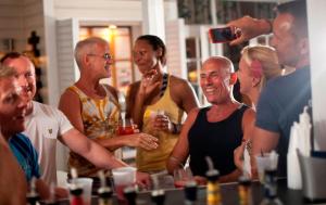 
a large group of people sitting around a table at Alexander's Gay Lesbian Guesthouse (Adult Only 21+) in Key West
