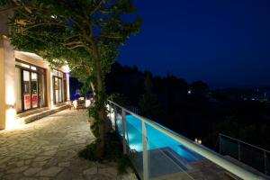 a villa with a swimming pool at night at Amalia Villas in Nydri