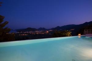 una piscina con vista sulla città di notte di Amalia Villas a Nydri
