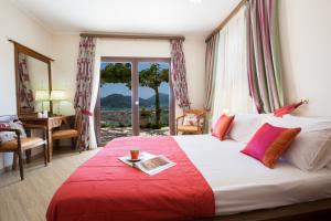 a bedroom with a large bed with a red blanket at Amalia Villas in Nydri