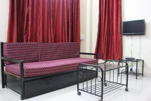 a red bench in front of some red curtains at Om Bungalow -Happy Stay At Panchgani in Panchgani