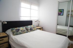 sypialnia z łóżkiem z poduszką i lustrem w obiekcie Las Palmas BEACH w mieście Las Palmas de Gran Canaria