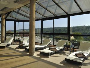 a group of chairs sitting in a room with windows at Auberge Du Camp Romain in Chassey-le-Camp